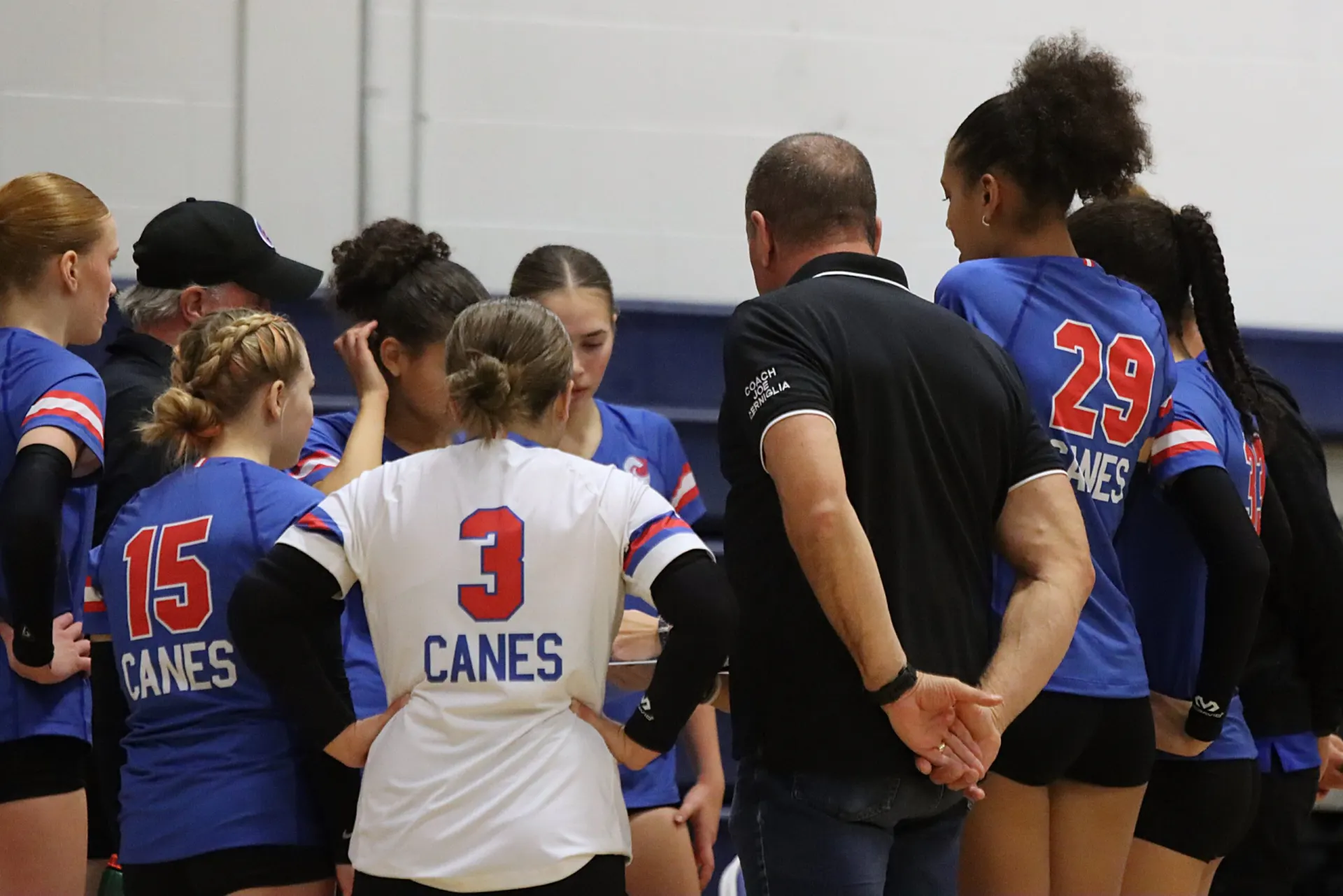 Coach Joe talking with a player between plays